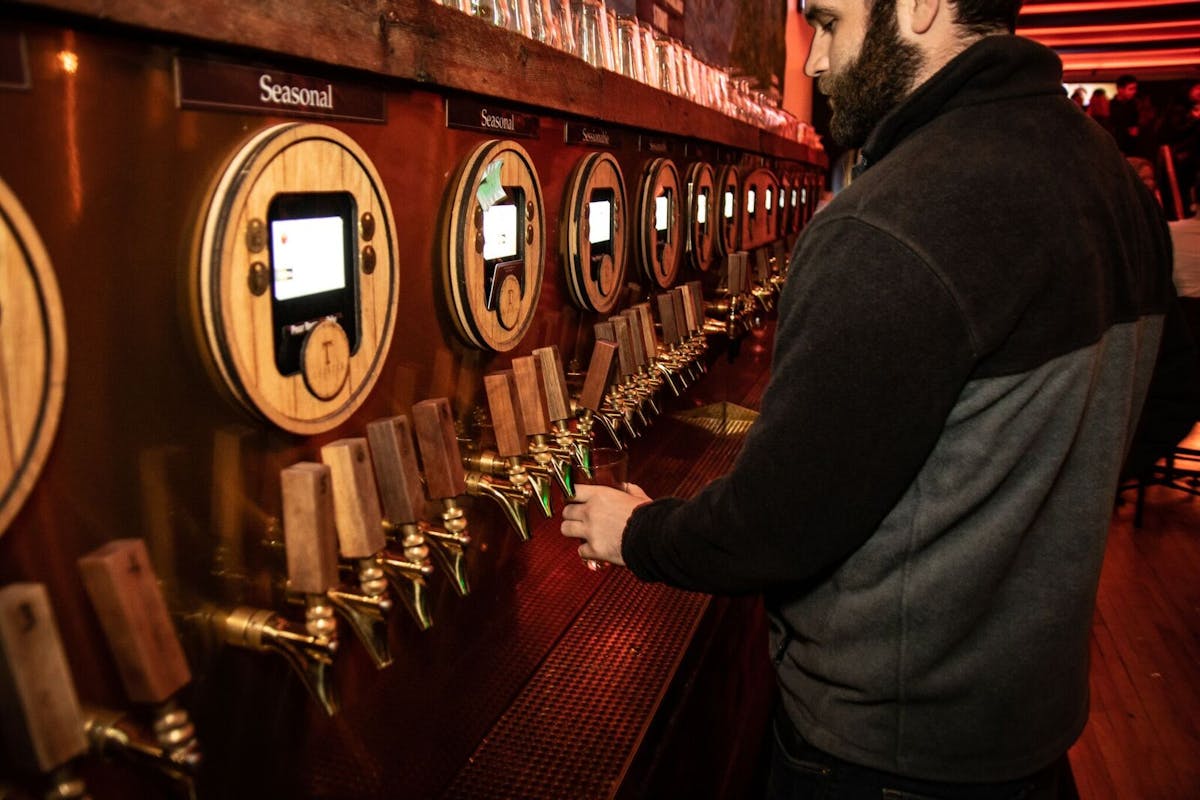 A man serving a glass of beer.